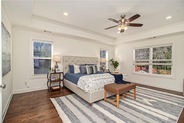 bedroom featuring baseboards, a tray ceiling, ornamental molding, recessed lighting, and wood finished floors