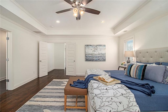 bedroom featuring baseboards, a raised ceiling, wood finished floors, and ornamental molding