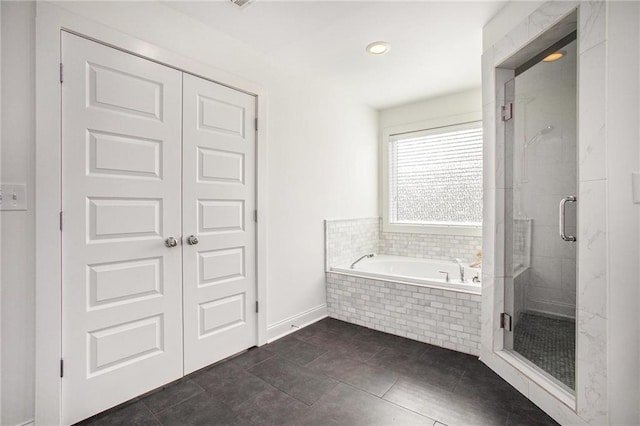 bathroom featuring a stall shower, baseboards, a bath, and tile patterned floors