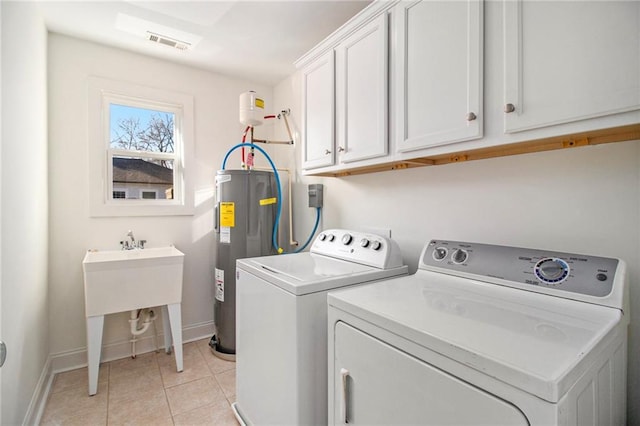 clothes washing area with visible vents, electric water heater, washing machine and dryer, cabinet space, and light tile patterned flooring