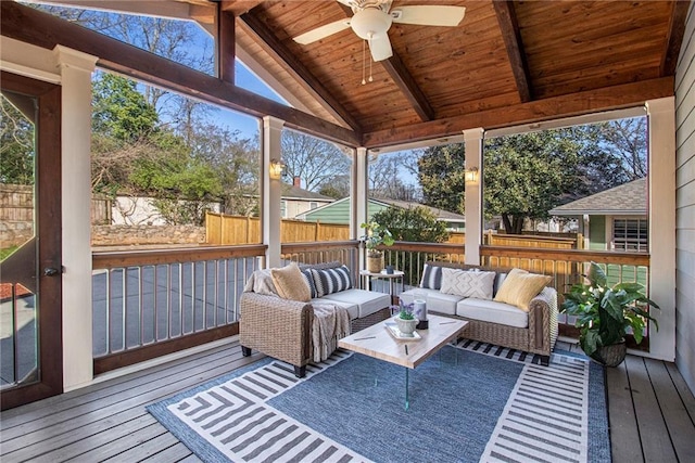 sunroom with lofted ceiling with beams, wooden ceiling, and ceiling fan