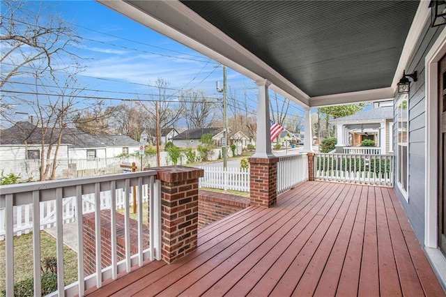 wooden terrace featuring a residential view and covered porch