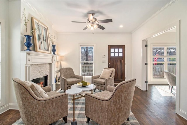 living room featuring baseboards, a ceiling fan, dark wood-style flooring, and ornamental molding