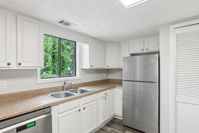 6249 Townsend Way, Riverdale, GA 30296 - kitchen featuring stainless steel appliances, white cabinetry, dark wood-type flooring, a textured ceiling, and light countertops