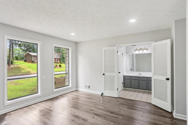 6249 Townsend Way, Riverdale, GA 30296 - unfurnished bedroom with wood finished floors, ensuite bathroom, recessed lighting, and a textured ceiling