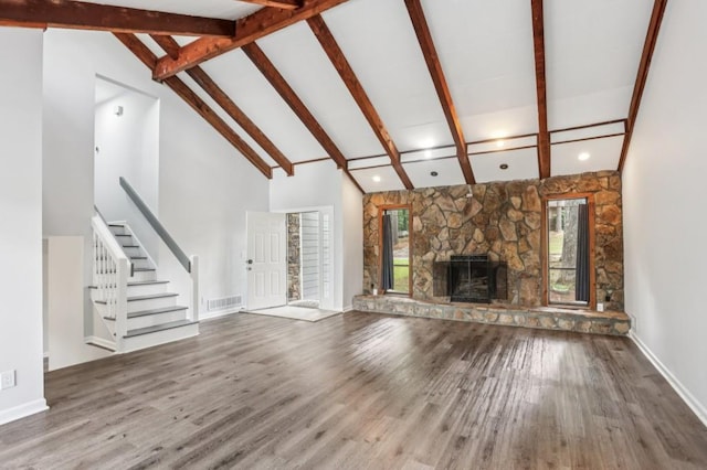 6249 Townsend Way, Riverdale, GA 30296 - unfurnished living room featuring wood finished floors, stairway, beamed ceiling, a fireplace, and high vaulted ceiling