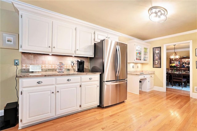 5020 Huntshire Ln SW, Lilburn, GA 30047 - kitchen with freestanding refrigerator, white cabinets, light wood-style floors, tasteful backsplash, and crown molding