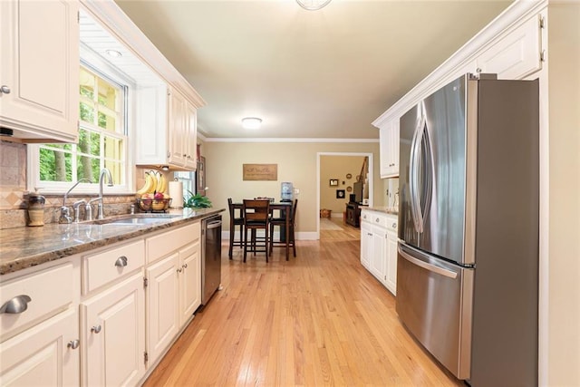 5020 Huntshire Ln SW, Lilburn, GA 30047 - kitchen featuring stainless steel appliances, white cabinets, light wood-type flooring, ornamental molding, and light stone countertops