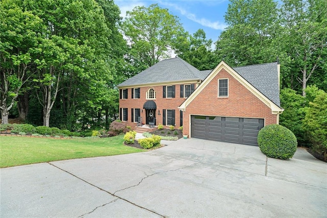 5020 Huntshire Ln SW, Lilburn, GA 30047 - view of front of property featuring driveway, brick siding, a front lawn, a shingled roof, and view of wooded area