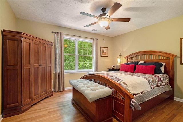 5020 Huntshire Ln SW, Lilburn, GA 30047 - bedroom featuring light wood-style floors, a textured ceiling, and ceiling fan