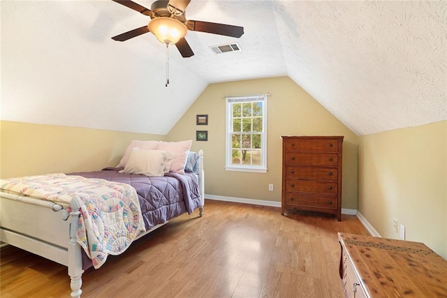 5020 Huntshire Ln SW, Lilburn, GA 30047 - bedroom with light wood-style flooring, lofted ceiling, a ceiling fan, and a textured ceiling