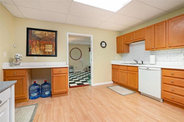 5020 Huntshire Ln SW, Lilburn, GA 30047 - kitchen featuring white dishwasher, a paneled ceiling, light countertops, light wood-type flooring, and tasteful backsplash