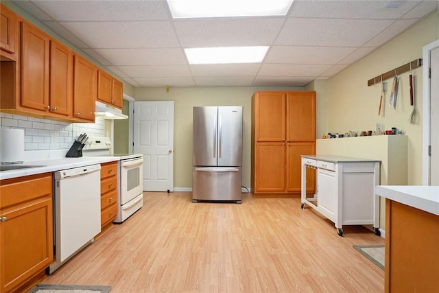 5020 Huntshire Ln SW, Lilburn, GA 30047 - kitchen featuring white appliances, under cabinet range hood, light wood-style floors, a drop ceiling, and light countertops
