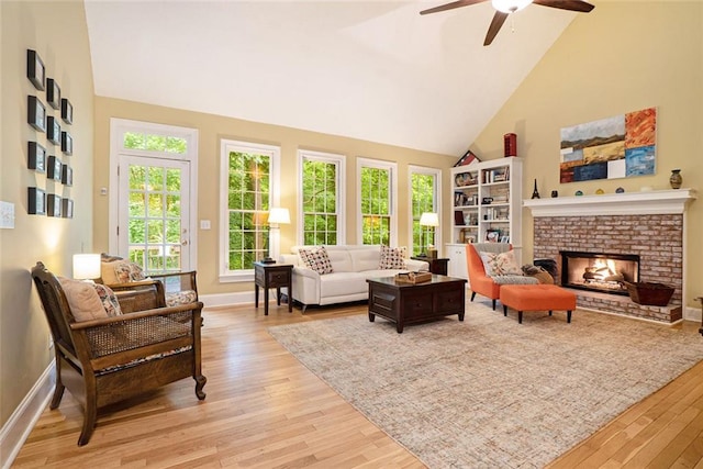 5020 Huntshire Ln SW, Lilburn, GA 30047 - living area featuring high vaulted ceiling, light wood finished floors, ceiling fan, and a brick fireplace