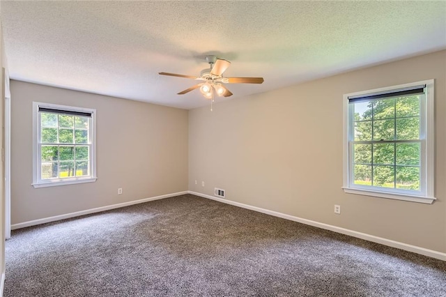 62 Sweetwater Pkwy, Powder Springs, GA 30127 - empty room with plenty of natural light, dark colored carpet, a ceiling fan, a textured ceiling, and baseboards