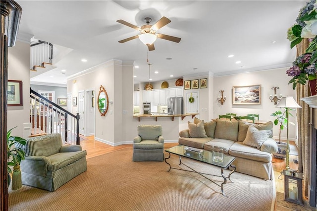 living area featuring recessed lighting, ceiling fan, stairs, crown molding, and light wood-style floors