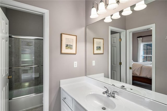 ensuite bathroom with bath / shower combo with glass door, ensuite bathroom, and vanity