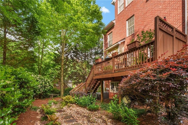 view of yard featuring central air condition unit, stairway, and a wooden deck