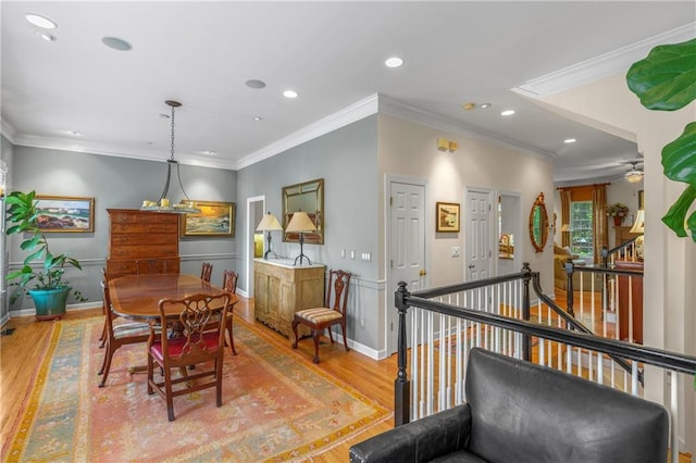 dining space with light wood finished floors, crown molding, baseboards, and recessed lighting