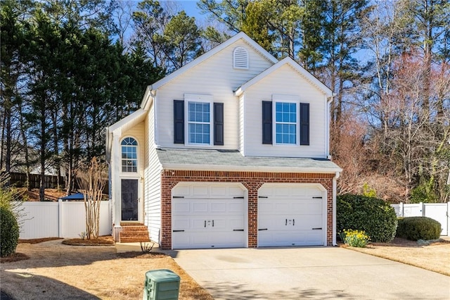 traditional home featuring brick siding, concrete driveway, an attached garage, and fence