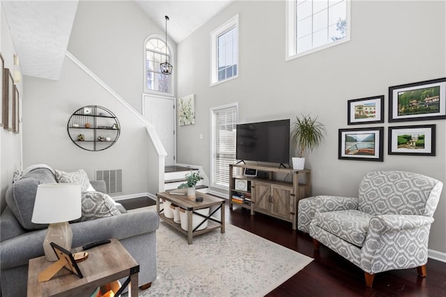 living room with visible vents, a healthy amount of sunlight, dark wood-type flooring, and baseboards