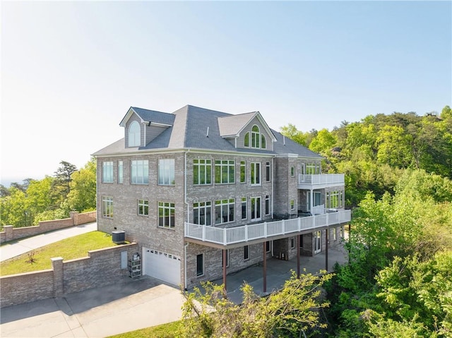 back of property with a garage and a balcony