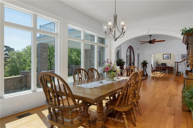 dining area with a healthy amount of sunlight, light hardwood / wood-style floors, and ornate columns