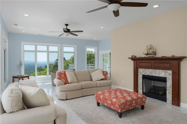 living room featuring a premium fireplace and ceiling fan