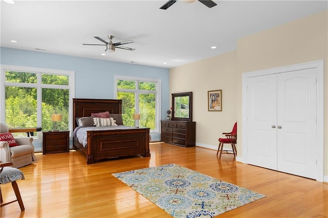 bedroom with ceiling fan, a closet, and light wood-type flooring