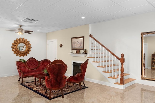 sitting room with a paneled ceiling and ceiling fan