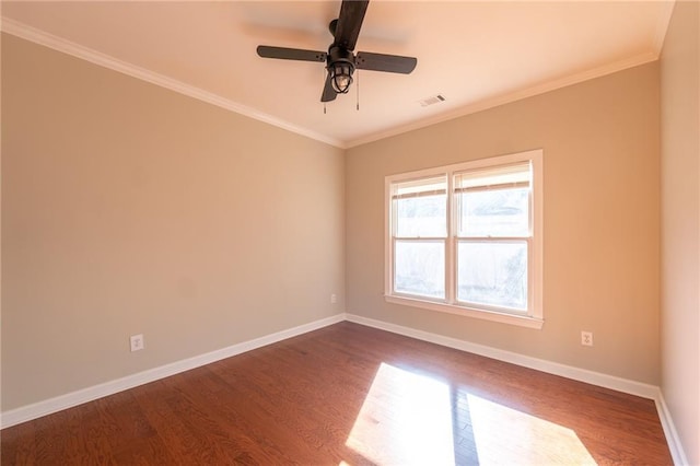 unfurnished room with dark wood-style floors, ornamental molding, visible vents, and baseboards