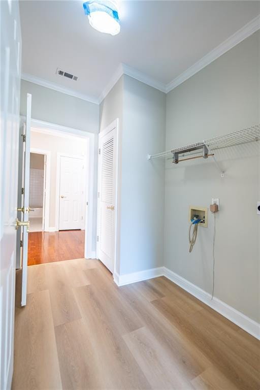 laundry room with light wood-style flooring, washer hookup, visible vents, baseboards, and crown molding