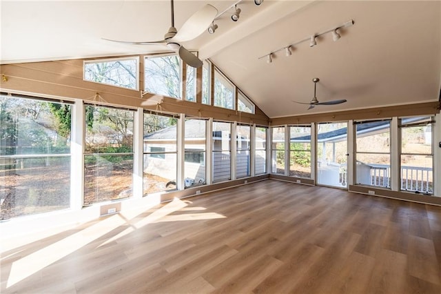 unfurnished sunroom with a ceiling fan, a healthy amount of sunlight, and vaulted ceiling with beams