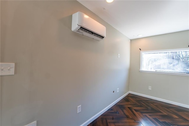 spare room with a wall unit AC and baseboards