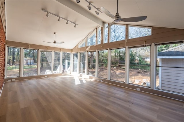 unfurnished sunroom featuring a ceiling fan, a healthy amount of sunlight, and vaulted ceiling