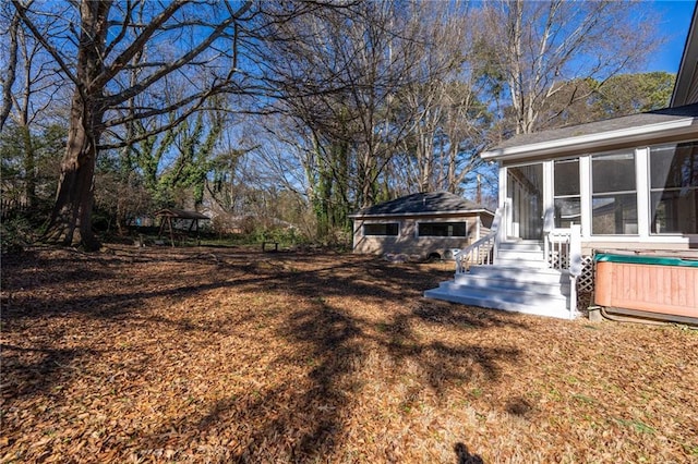 view of yard featuring a sunroom and an outdoor structure