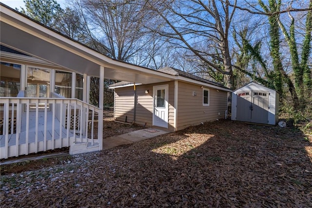 view of home's exterior with an outbuilding, a storage unit, and a wooden deck