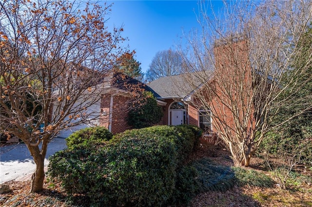 obstructed view of property with driveway and brick siding