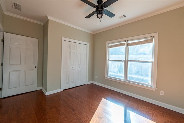 unfurnished bedroom featuring baseboards, visible vents, dark wood finished floors, and ornamental molding