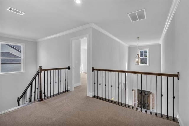 hallway with crown molding, carpet floors, and a chandelier