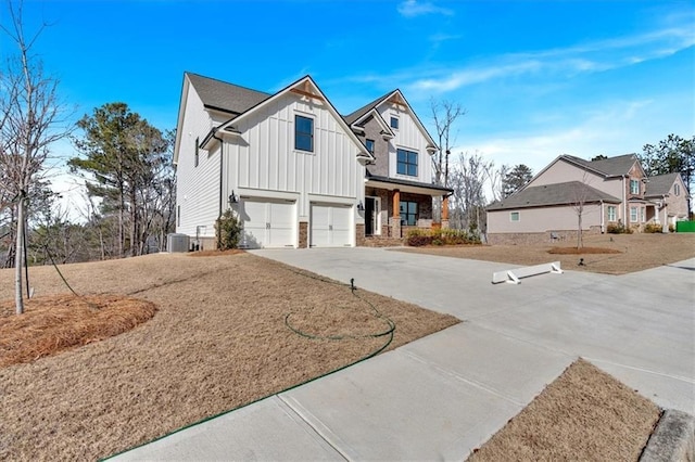 view of front of house with a garage, covered porch, a front lawn, and central air condition unit