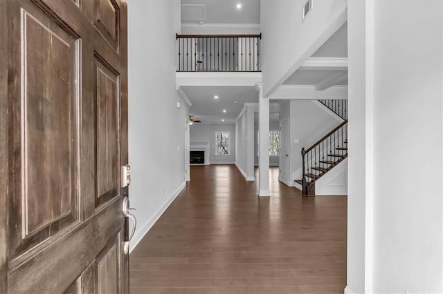 foyer featuring crown molding, beam ceiling, and dark wood-type flooring