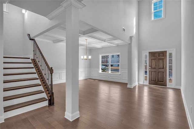 entryway with a healthy amount of sunlight, coffered ceiling, an inviting chandelier, and beam ceiling