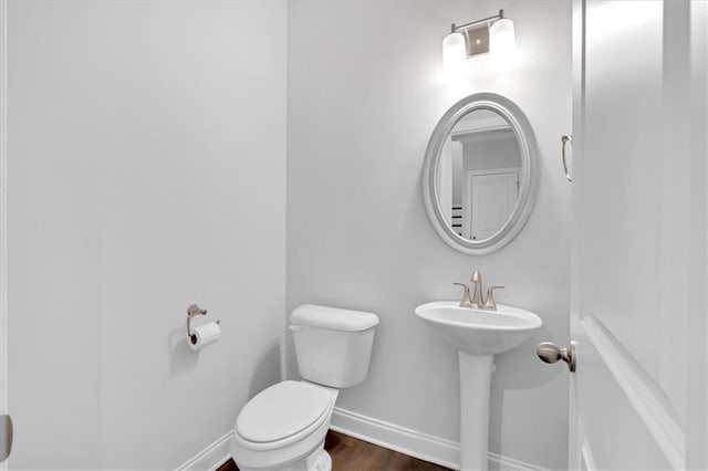 bathroom featuring hardwood / wood-style flooring and toilet