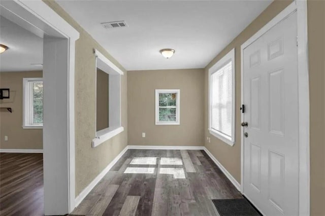 foyer featuring wood finished floors, visible vents, and baseboards