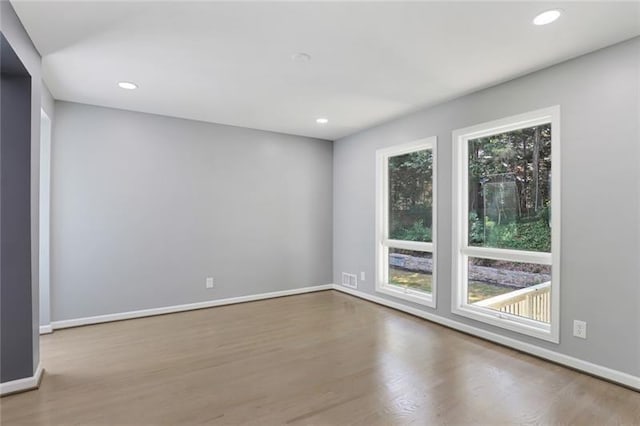 unfurnished room with recessed lighting, visible vents, baseboards, and wood finished floors