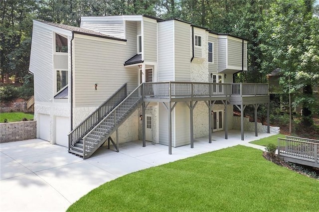 back of property featuring a patio, a yard, concrete driveway, a garage, and stairs