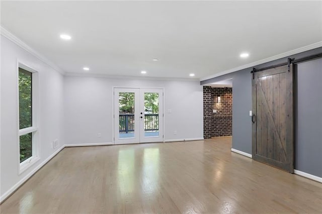 spare room with crown molding, baseboards, and wood finished floors