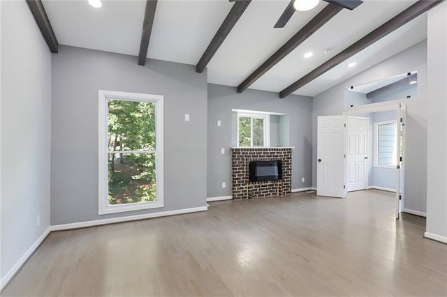 unfurnished living room with vaulted ceiling with beams, baseboards, and wood finished floors