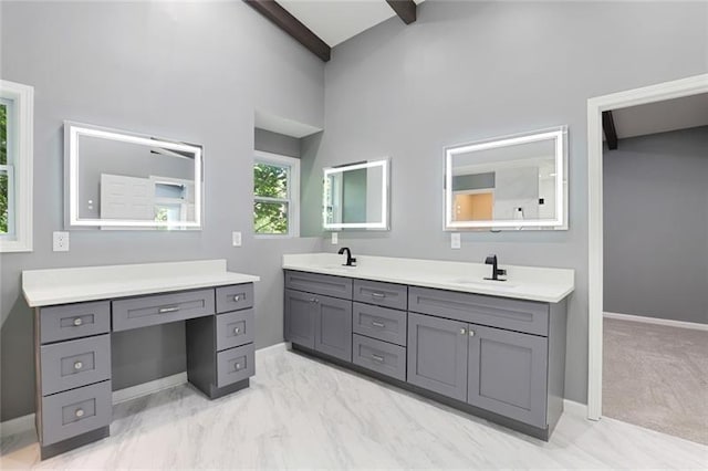 bathroom featuring double vanity, baseboards, and a sink